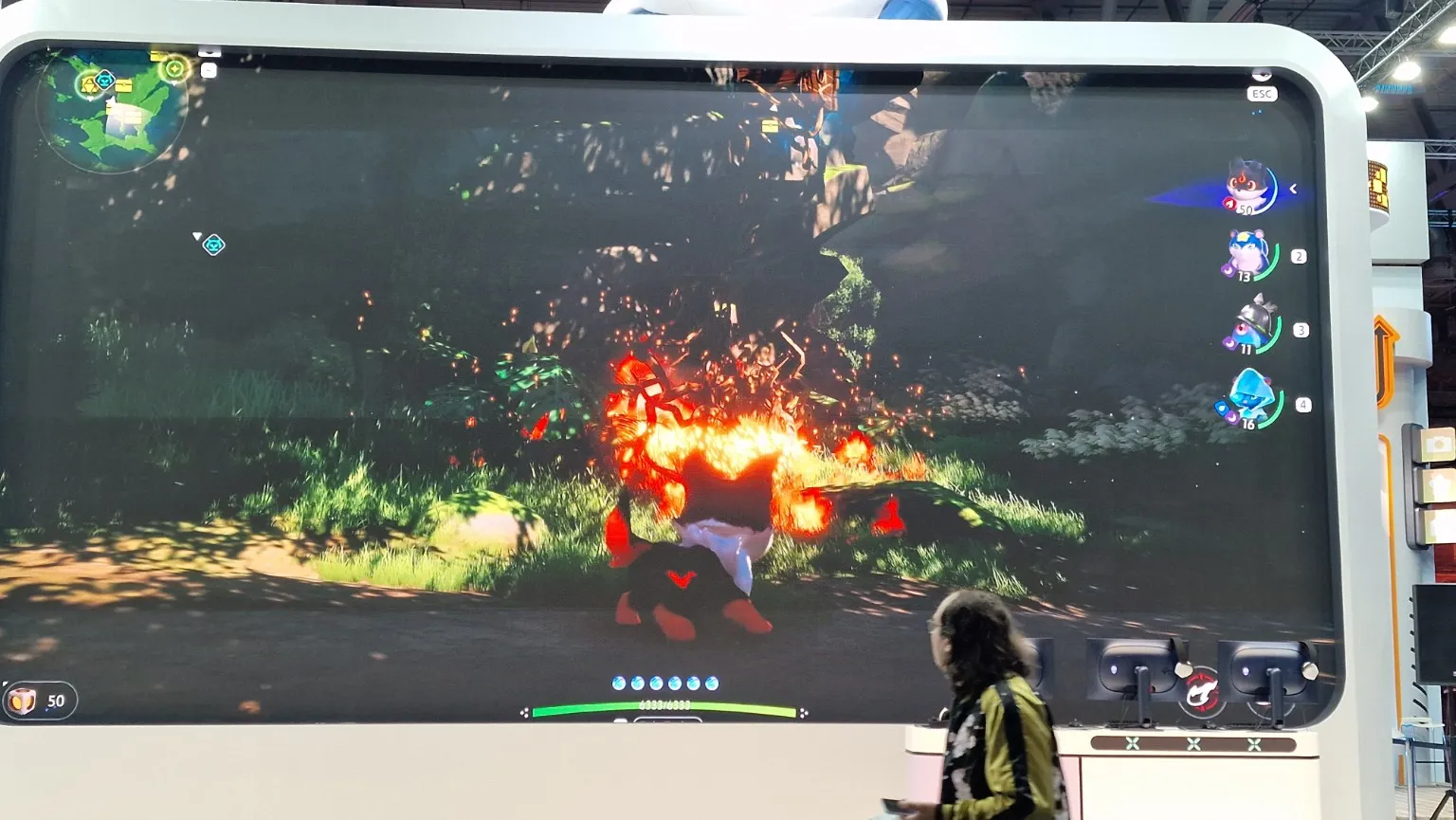 Aniimo game footage on the large screen at the booth.